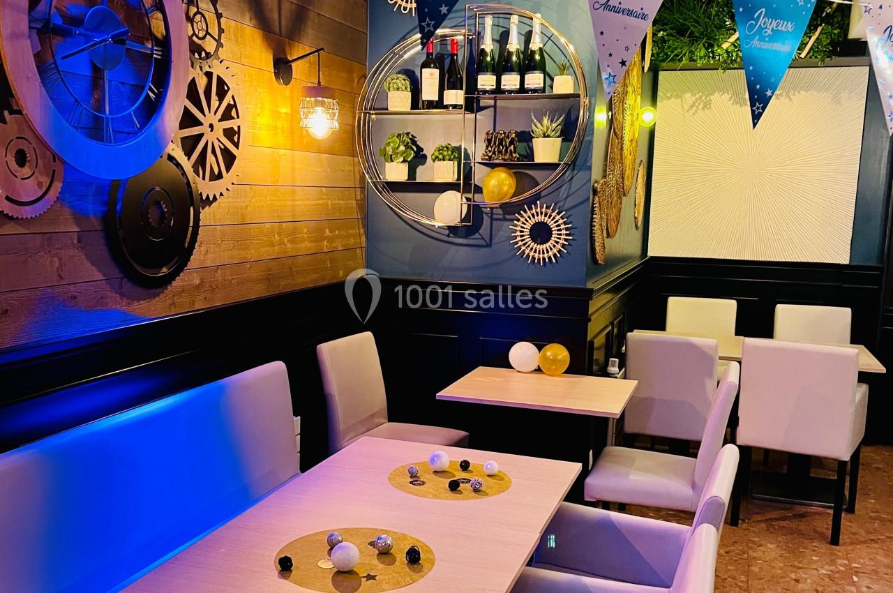 Salle de restaurant décorée avec des tables en bois clair, des chaises blanches et des éléments muraux modernes.