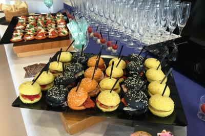 Assortiment de salades dans des bols noirs : salade de pommes de terre, tomates cerises et pâtes au pesto.