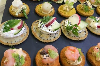 Assortiment de salades dans des bols noirs : salade de pommes de terre, tomates cerises et pâtes au pesto.