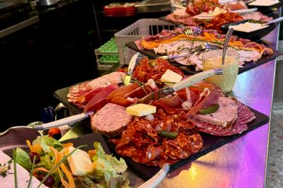 Assortiment de salades dans des bols noirs : salade de pommes de terre, tomates cerises et pâtes au pesto.