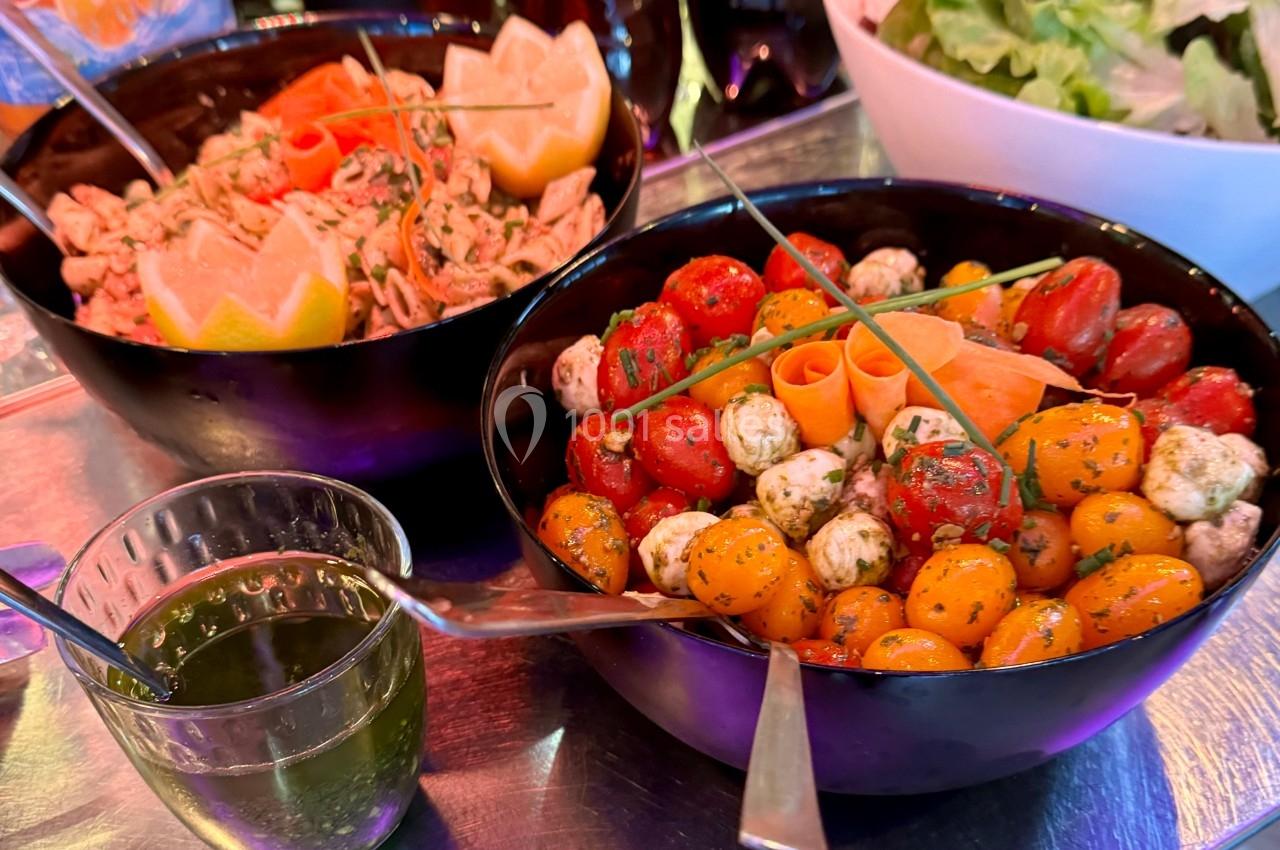 Deux bols contenant une salade de tomates cerises, mozzarella et herbes, et une salade de crevettes avec agrumes.