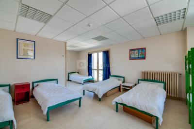 Deux roulottes rouges avec portes vertes, posées sur un terrain herbeux devant des arbres en automne.