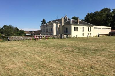 Deux roulottes rouges avec portes vertes, posées sur un terrain herbeux devant des arbres en automne.