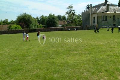 Deux roulottes rouges avec portes vertes, posées sur un terrain herbeux devant des arbres en automne.