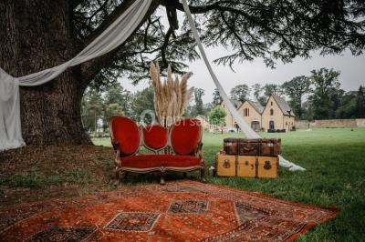 Véranda lumineuse avec murs en briques, grandes baies vitrées noires et vue sur un jardin verdoyant.
