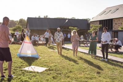 Véranda lumineuse avec murs en briques, grandes baies vitrées noires et vue sur un jardin verdoyant.