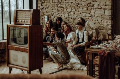 Véranda lumineuse avec murs en briques, grandes baies vitrées noires et vue sur un jardin verdoyant.