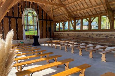 Véranda lumineuse avec murs en briques, grandes baies vitrées noires et vue sur un jardin verdoyant.