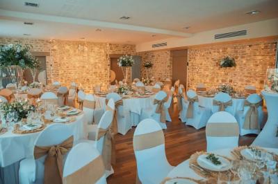 Véranda lumineuse avec murs en briques, grandes baies vitrées noires et vue sur un jardin verdoyant.