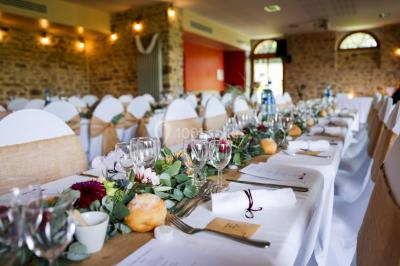 Véranda lumineuse avec murs en briques, grandes baies vitrées noires et vue sur un jardin verdoyant.