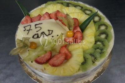 Composition décorative en forme d'ananas réalisée avec des légumes frais comme carottes, radis, tomates et chou-fleur.