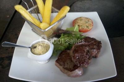 Composition décorative en forme d'ananas réalisée avec des légumes frais comme carottes, radis, tomates et chou-fleur.