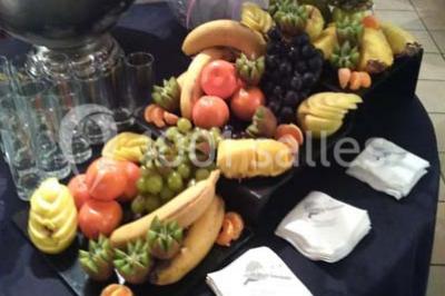 Composition décorative en forme d'ananas réalisée avec des légumes frais comme carottes, radis, tomates et chou-fleur.