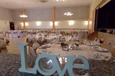 Cour extérieure avec végétation tropicale, terrasse ensoleillée, murs jaunes et mobilier en bois près d'une pergola.