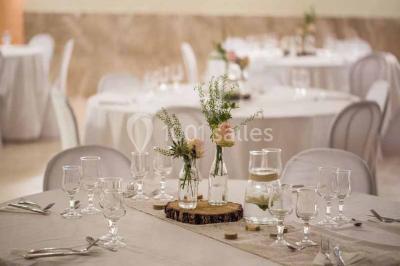 Cour extérieure avec végétation tropicale, terrasse ensoleillée, murs jaunes et mobilier en bois près d'une pergola.