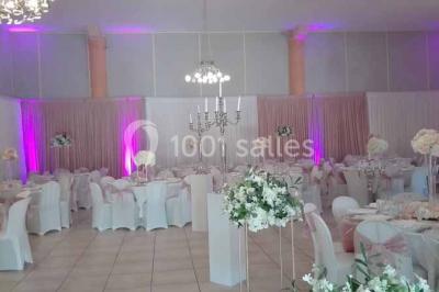 Cour extérieure avec végétation tropicale, terrasse ensoleillée, murs jaunes et mobilier en bois près d'une pergola.