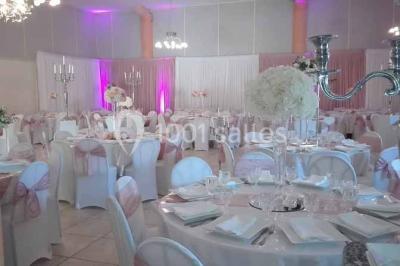 Cour extérieure avec végétation tropicale, terrasse ensoleillée, murs jaunes et mobilier en bois près d'une pergola.