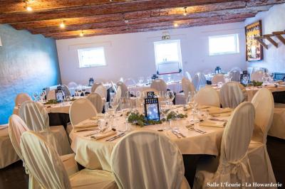 Un couple danse au centre d'une salle éclairée, entouré d'invités assis à des tables.