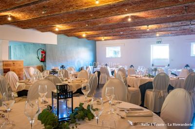 Un couple danse au centre d'une salle éclairée, entouré d'invités assis à des tables.
