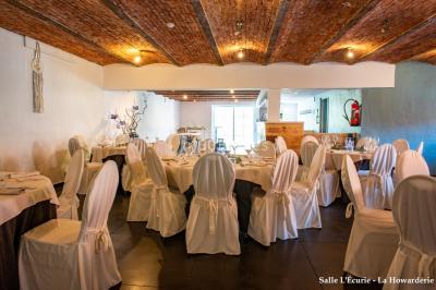Un couple danse au centre d'une salle éclairée, entouré d'invités assis à des tables.