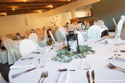 Un couple danse au centre d'une salle éclairée, entouré d'invités assis à des tables.