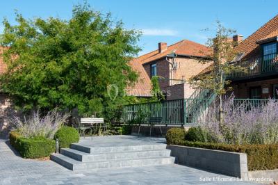 Un couple danse au centre d'une salle éclairée, entouré d'invités assis à des tables.