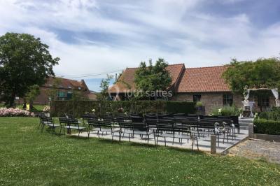 Un couple danse au centre d'une salle éclairée, entouré d'invités assis à des tables.