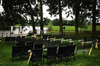 Un couple danse au centre d'une salle éclairée, entouré d'invités assis à des tables.
