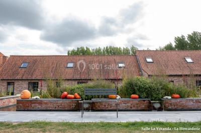 Un couple danse au centre d'une salle éclairée, entouré d'invités assis à des tables.