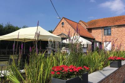 Un couple danse au centre d'une salle éclairée, entouré d'invités assis à des tables.