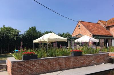 Un couple danse au centre d'une salle éclairée, entouré d'invités assis à des tables.