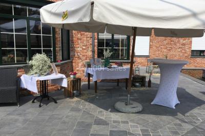 Un couple danse au centre d'une salle éclairée, entouré d'invités assis à des tables.