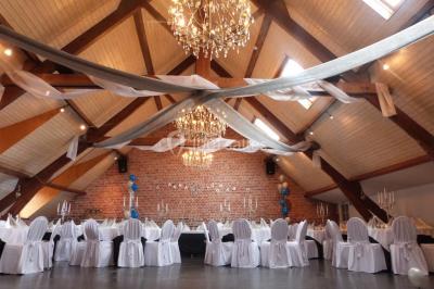 Un couple danse au centre d'une salle éclairée, entouré d'invités assis à des tables.
