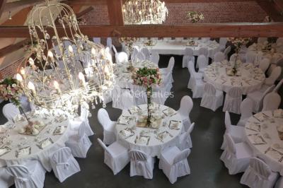 Un couple danse au centre d'une salle éclairée, entouré d'invités assis à des tables.