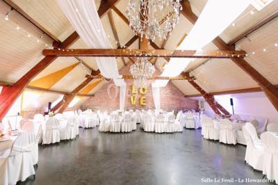 Un couple danse au centre d'une salle éclairée, entouré d'invités assis à des tables.