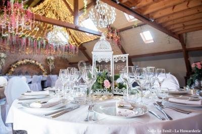 Un couple danse au centre d'une salle éclairée, entouré d'invités assis à des tables.
