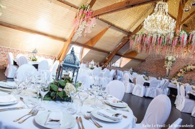 Un couple danse au centre d'une salle éclairée, entouré d'invités assis à des tables.