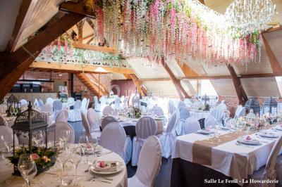 Un couple danse au centre d'une salle éclairée, entouré d'invités assis à des tables.