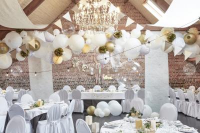 Un couple danse au centre d'une salle éclairée, entouré d'invités assis à des tables.