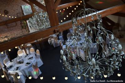 Un couple danse au centre d'une salle éclairée, entouré d'invités assis à des tables.