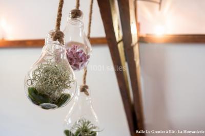 Un couple danse au centre d'une salle éclairée, entouré d'invités assis à des tables.