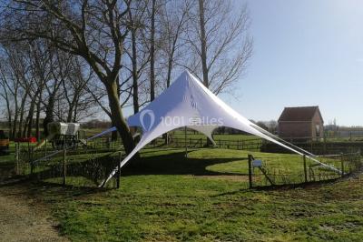 Un couple danse au centre d'une salle éclairée, entouré d'invités assis à des tables.