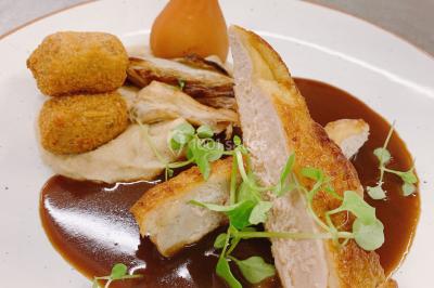 Un couple danse au centre d'une salle éclairée, entouré d'invités assis à des tables.