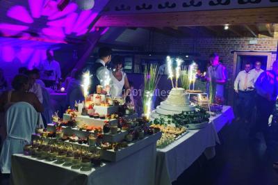 Un couple danse au centre d'une salle éclairée, entouré d'invités assis à des tables.