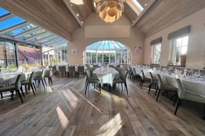 Un couple danse au centre d'une salle éclairée, entouré d'invités assis à des tables.