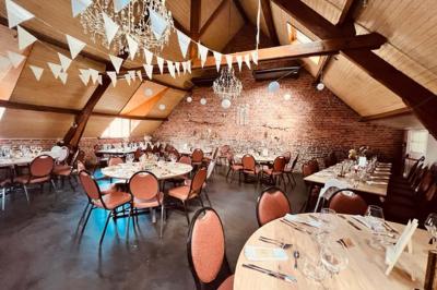 Un couple danse au centre d'une salle éclairée, entouré d'invités assis à des tables.