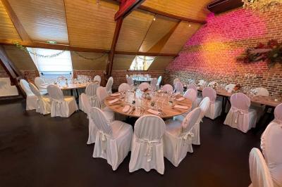 Un couple danse au centre d'une salle éclairée, entouré d'invités assis à des tables.