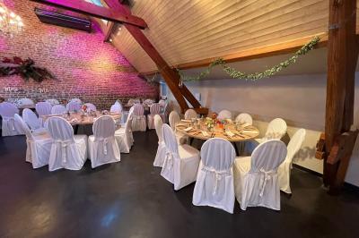 Un couple danse au centre d'une salle éclairée, entouré d'invités assis à des tables.