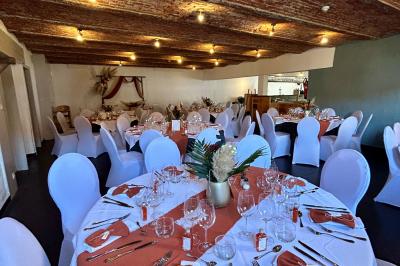 Un couple danse au centre d'une salle éclairée, entouré d'invités assis à des tables.