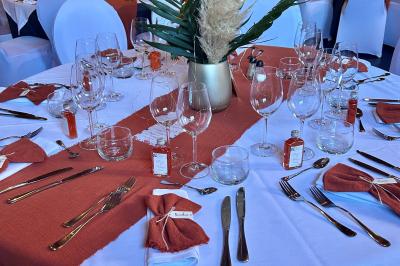Un couple danse au centre d'une salle éclairée, entouré d'invités assis à des tables.